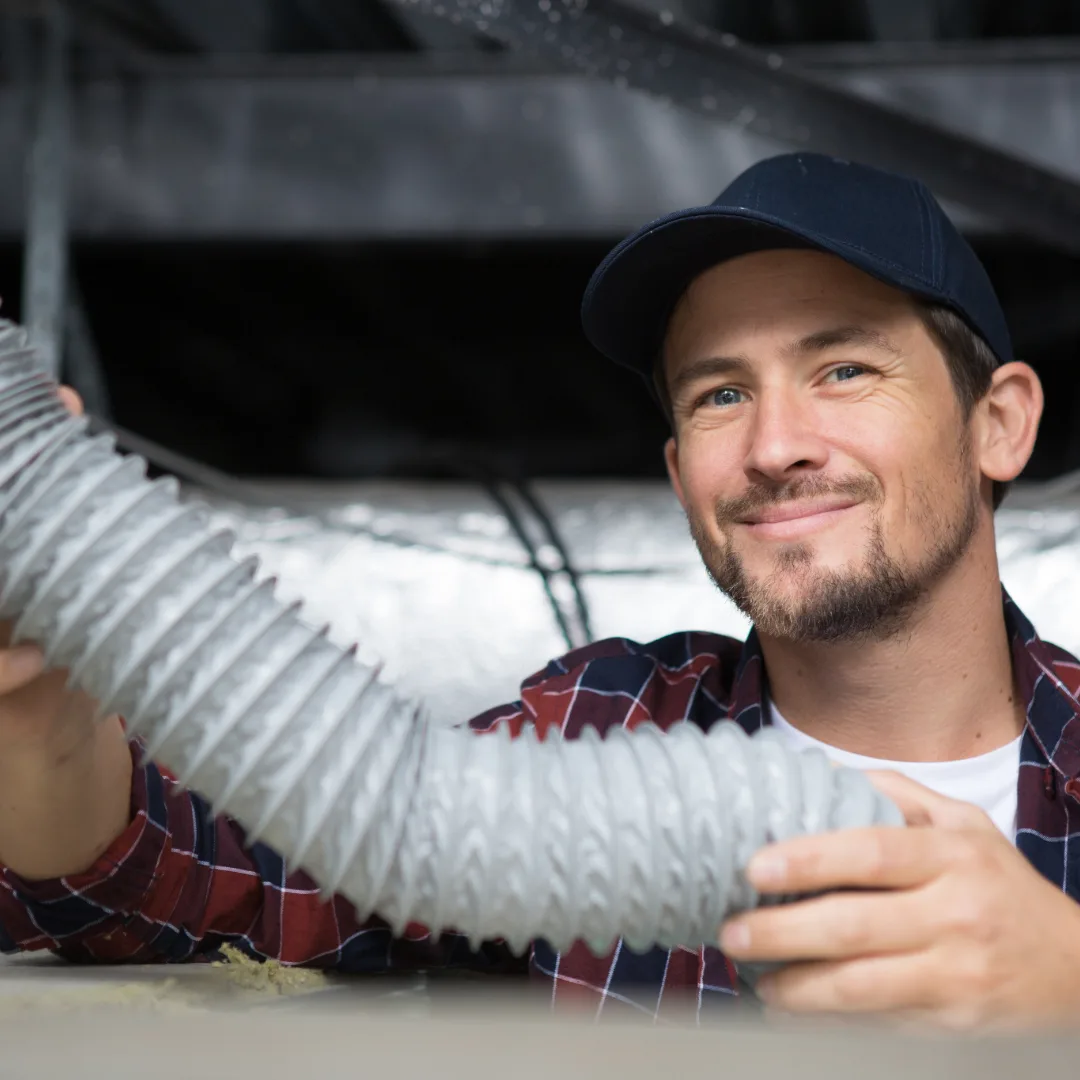 Worker holding a flexible air duct.