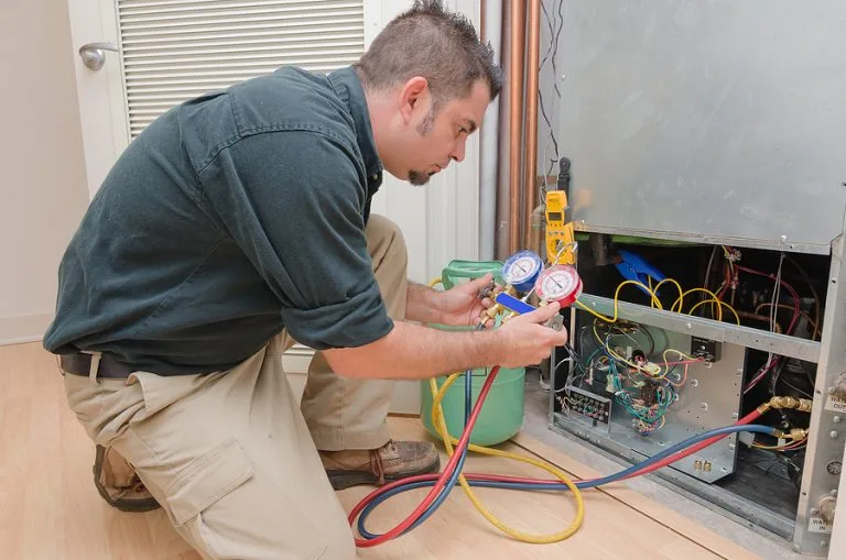 HVAC technician performing indoor air conditioning maintenance