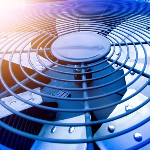 Close-up of an air conditioner fan and metal grille.
