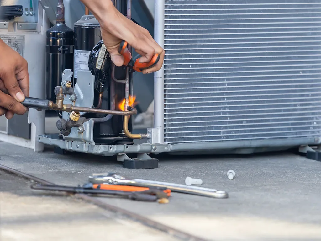 HVAC technician repairing air conditioner compressor and cooling system